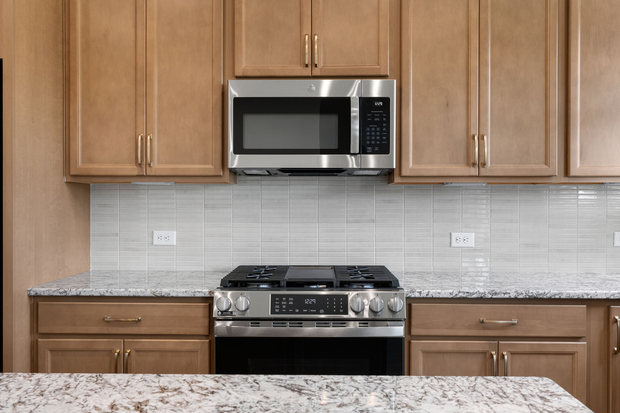 Gas range and tile backsplash in the kitchen at 9312 Woodgate Circle in Alvaton, KY