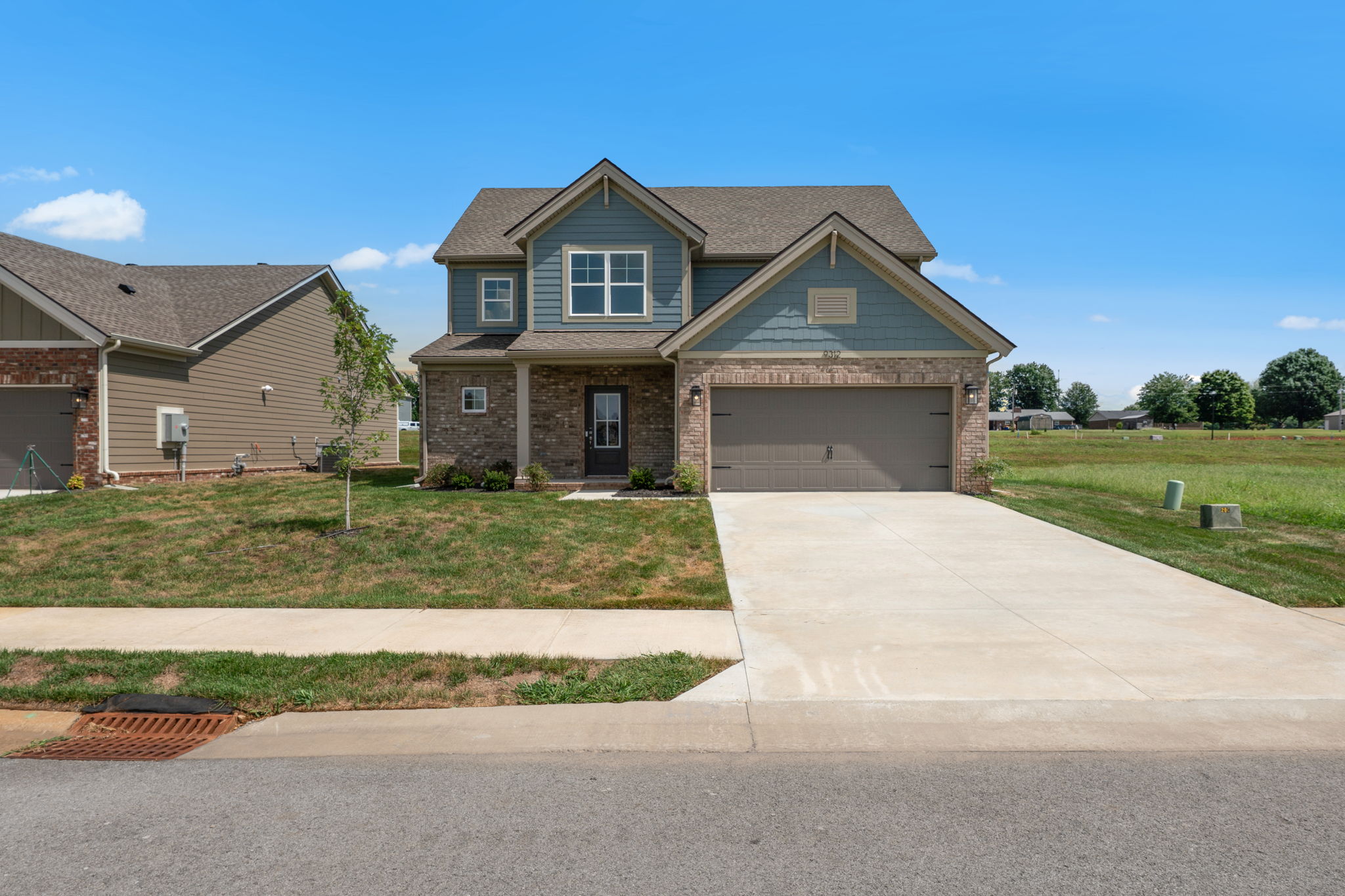 Street view of the front elevation and two-car garage at 9312 Woodgate Circle in Alvaton, KY